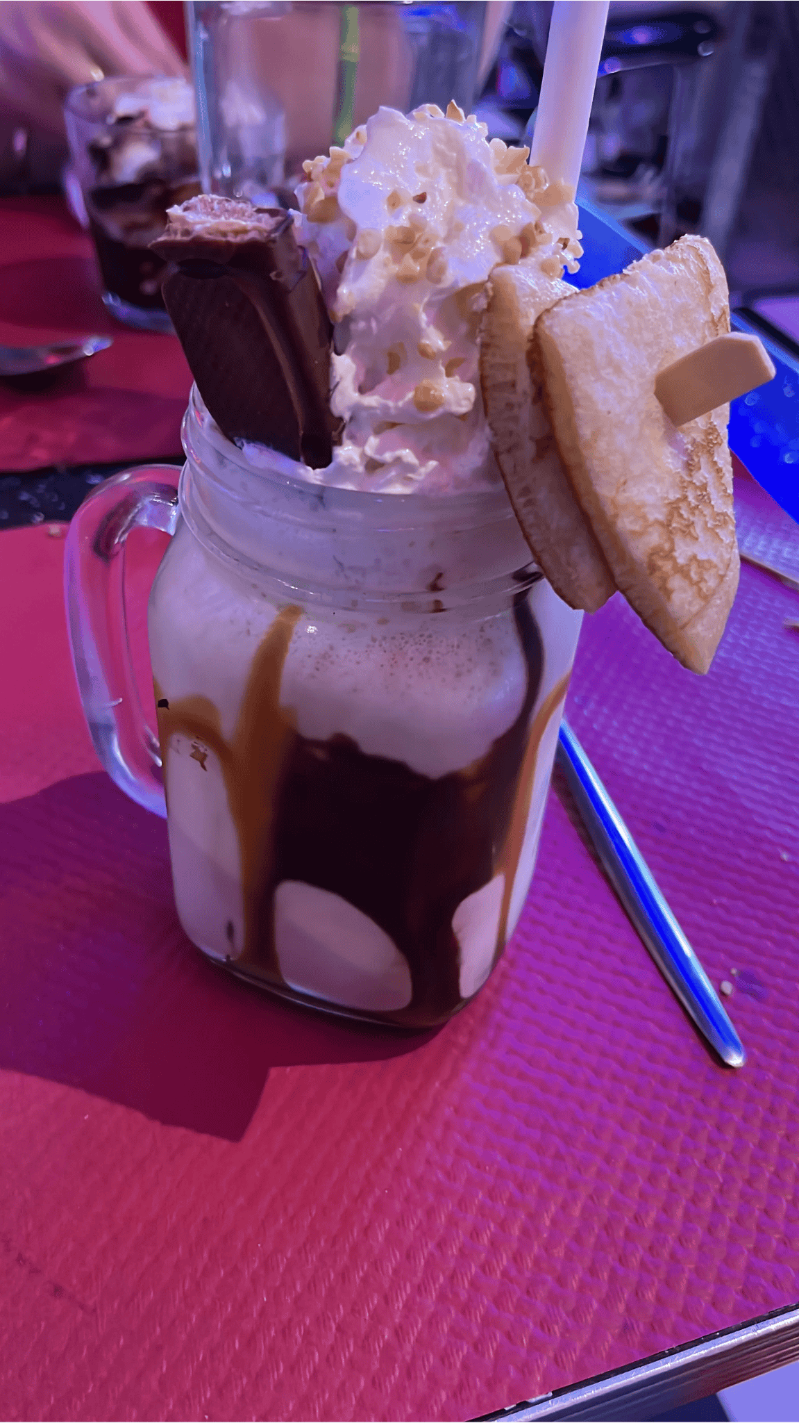 Photo d'un énorme milkshake avec des waffles et de la chantilly